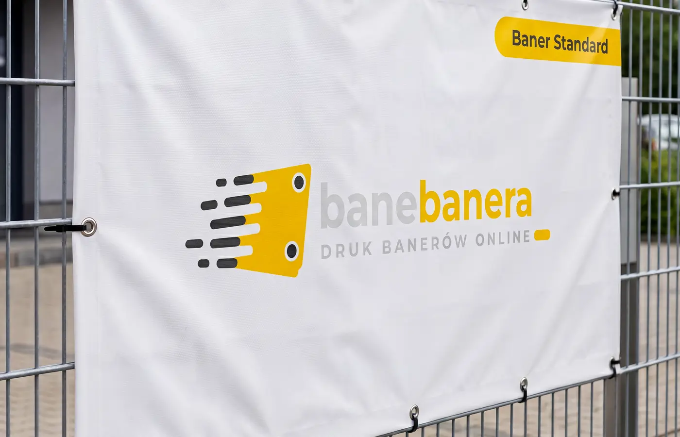 Baner standard laminowany zawieszony na ogrodzeniu